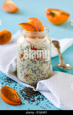 Yogurt with chia seeds and goji berries served with cut persimmon Stock Photo