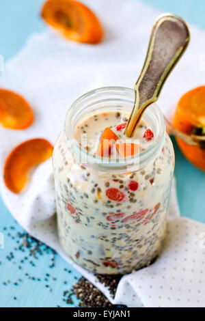 Chia pudding with persimmon and goji berries served in a glass jar Stock Photo