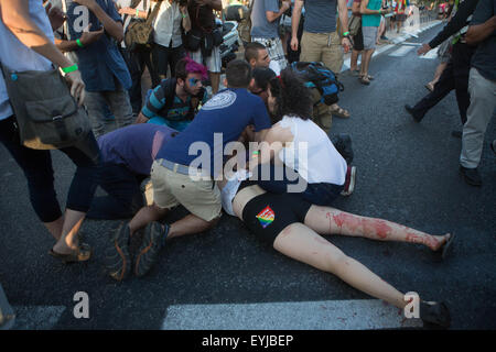 Jerusalem. 30th July, 2015. People help a young Israeli to stanch the wound in a stabbing attack during the annual gay pride parade in Jerusalem, . Six people were stabbed at Jerusalem's annual gay pride parade on Thursday, in one of the gravest attacks on the gay community in Israel, Israeli officials and eyewitnesses told Xinhua. A police spokesperson said the assailant was captured and identified as Yishai Schlissel, a Jewish ultra-Orthodox man who carried out a similar attack in 2005, injuring three people. Credit:  Xinhua/Alamy Live News Stock Photo