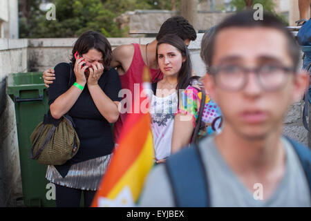 Jerusalem. 30th July, 2015. A woman cries while making a phone call after a stabbing attack during the annual gay pride parade in Jerusalem, . Six people were stabbed at Jerusalem's annual gay pride parade on Thursday, in one of the gravest attacks on the gay community in Israel, Israeli officials and eyewitnesses told Xinhua. A police spokesperson said the assailant was captured and identified as Yishai Schlissel, a Jewish ultra-Orthodox man who carried out a similar attack in 2005, injuring three people. Credit:  Xinhua/Alamy Live News Stock Photo