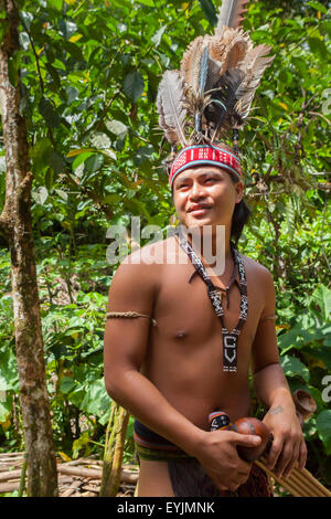 A tourism worker wearing indigenous attire is posing for tourists at Mari Mari Cultural Village on the outskirts of Kota Kinabalu in Sabah, Malaysia. Stock Photo
