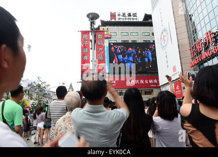 Beijing, China. 31st July, 2015. People watch a video broadcasting the bid to host the 2022 Olympic Winter Games at Wangfujing Street in Beijing, capital of China, July 31, 2015. Credit:  Jin Liangkuai/Xinhua/Alamy Live News Stock Photo