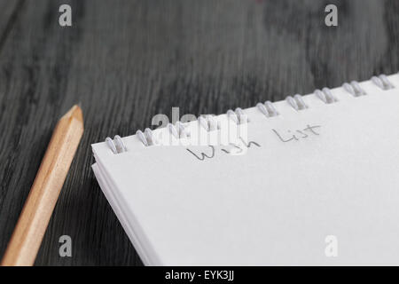 closeup photo of open empty notepad with wish list phrase Stock Photo