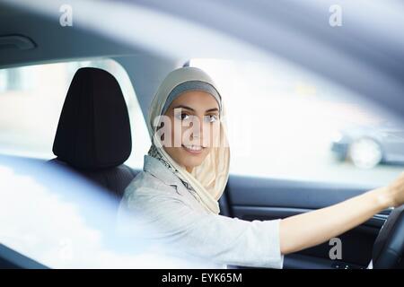 Portrait of young businesswoman wearing hijab driving car Stock Photo