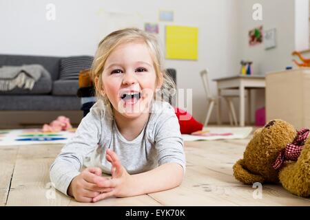Girl lying on floor at home Stock Photo - Alamy