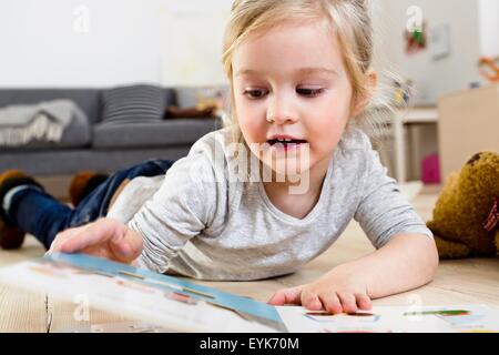 Girl lying on floor at home Stock Photo - Alamy