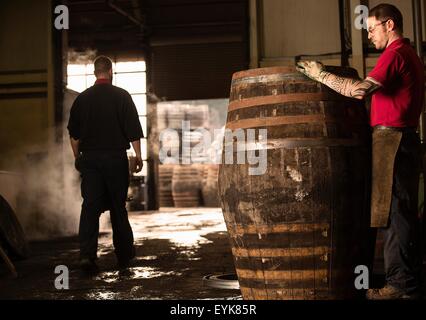 Male cooper working in cooperage with whisky cask Stock Photo