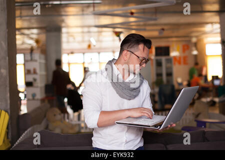 Stylish man using smartphone in startup office Stock Photo
