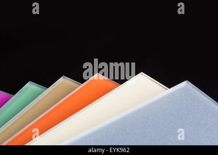 a stack of colored glass on a black background. glass sheets Stock Photo
