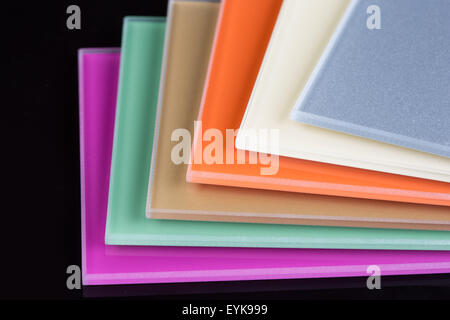 a stack of colored glass on a black background. glass sheets Stock Photo