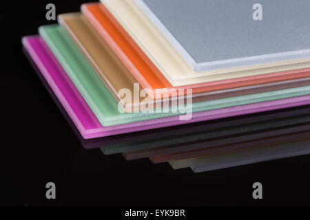 a stack of colored glass on a black background. glass sheets Stock Photo