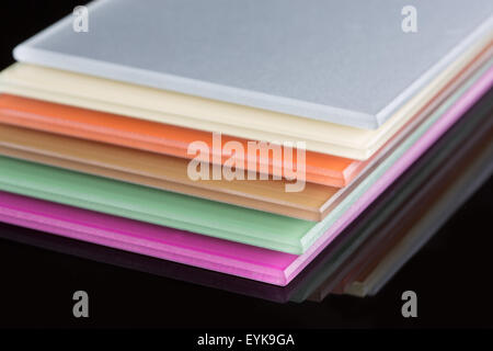 a stack of colored glass on a black background. glass sheets Stock Photo