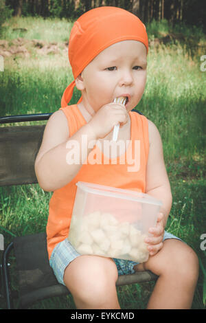 Cute baby eating fruits outdoor Stock Photo