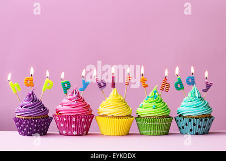 Cupcakes with candles spelling the words 'happy birthday' Stock Photo