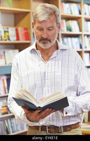 Male Customer Reading Book In Bookstore Stock Photo