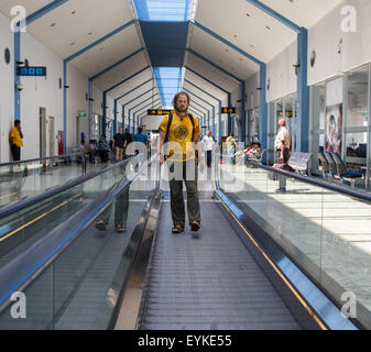 Business man going up escalator holding travel bag Stock Photo