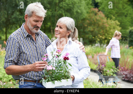 Mature Couple Choosing Plants At Garden Center Stock Photo