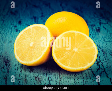 Vintage retro effect filtered hipster style image of lemon and cut half slice on blue wooden background Stock Photo