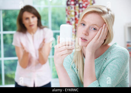 Mother Arguing With Teenage Daughter Over Use Of Mobile Phone Stock Photo