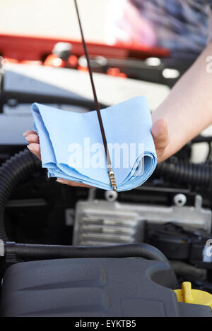 Close-Up Of Woman Checking Car Engine Oil Level On Dipstick Stock Photo