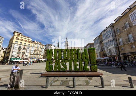 Local taking water with vegetable sculpture in grass of Vitoria Gasteiz in Plaza de la Virgen Blanca Stock Photo