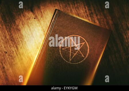 Old Mysterious Book with Pentagram Sign on the Cover. Stock Photo