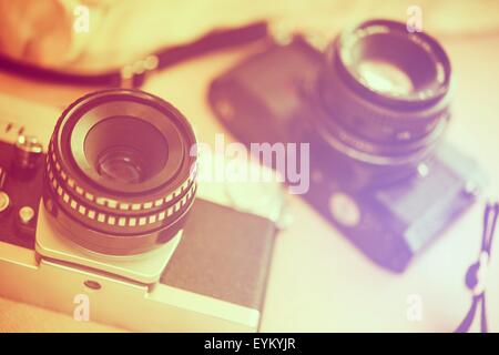 Vintage Photography Cameras Closeup Photo. Old Cameras on Table. Vintage Look Color Grading. Stock Photo