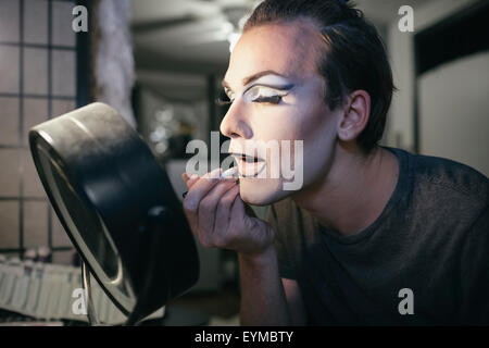 Male drag queen putting on make up and dressing up in preparation for a performance Stock Photo