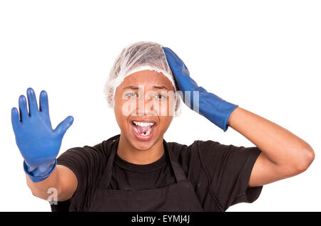 Closeup hispanic young man wearing blue cleaning gloves and plastic showercap touching his own head with one hand while other arm raised towards camera as a stop symbol. Stock Photo