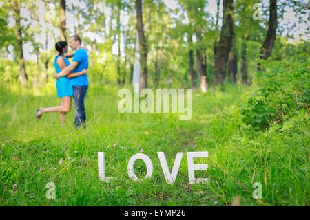 White letters forming word LOVE standing on green grass Stock Photo