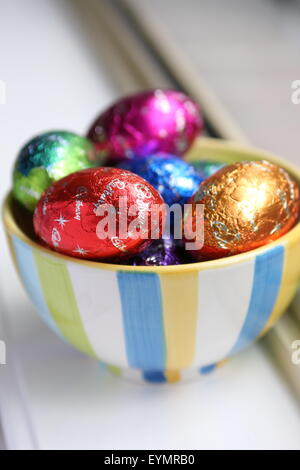 Cadbury Easter eggs chocolates in the bowl near the window Stock Photo