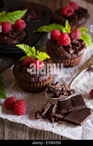 Chocolate raspberry yogurt muffins with pieces of chocolate and muffin tin Stock Photo
