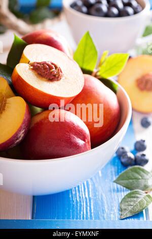 Fresh nectarines in a bowl with colorful background Stock Photo