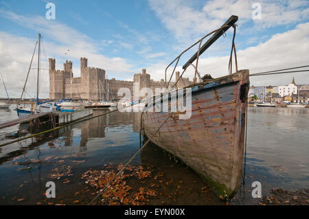 Old boat moored in Caernarfon estuary opposite Caernarfon Castle. Stock Photo