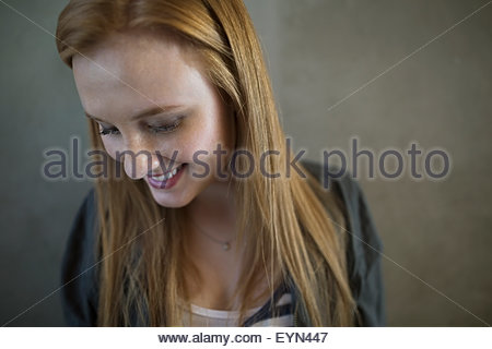 Portrait smiling young woman red hair looking down
