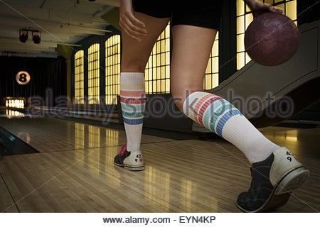 Young woman with knee-high socks bowling
