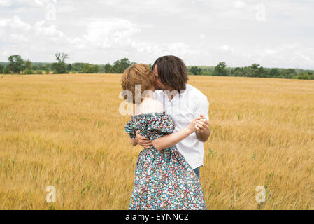 Loving middle-aged couple standing in a field in summer Stock Photo