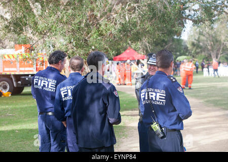 Australian fire officers firemen talking to a police officer at a military tattoo in Sydney,Australia Stock Photo