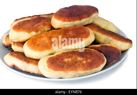 Mouth-watering freshly baked pies on a white ceramic dish. Presented on a white background. Stock Photo
