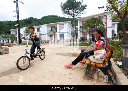 Zhaotong, July 31. 3rd Aug, 2014. Local residents rest at a resettlement community for victims of the Ludian earthquake one year ago in Qiaojia County, southwest China's Yunnan Province, July 31, 2015. A 6.5-magnitude earthquake jolted Ludian County in Yunnan at 4:30 p.m. on Aug. 3, 2014. As one year has passed, the post-disaster reconstruction for the quake victims has been pushing forward orderly. Credit:  Zhang Guangyu/Xinhua/Alamy Live News Stock Photo