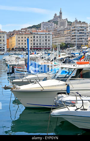 Marseilles France The Old Port of Marseille Vieux Port & French Notre Dame de la Garde church on hilltop overlooking small boats moored in harbour Stock Photo
