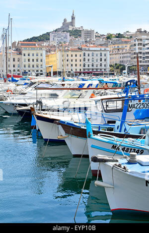 Marseille Vieux Port & French church of Notre Dame de la Garde on hilltop overlooking boats moored in The Old Port of Marseilles Mediterranean France Stock Photo