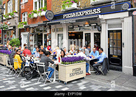 Pizza Express restaurant with people eating out dining outdoors in St Christophers Place off Oxford Street summer alfresco dining London West End UK Stock Photo