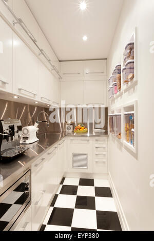 Small white coloured kitchen with chess tile floor Stock Photo