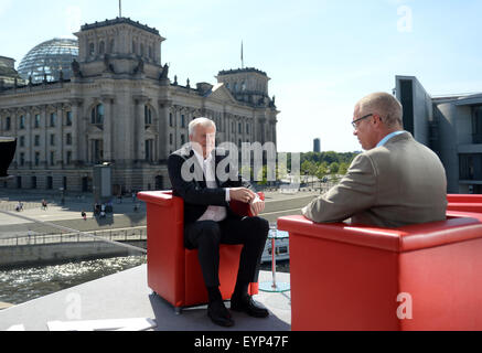 Berlin, Germany. 02nd Aug, 2015. Horst Seehofer (L), Premier of the German state Bavaria, sits in a red armchair facing presenter Rainald Becker prior to an interview with German public broadcaster ARD in front of the Reichstag building in Berlin, Germany, 02 August 2015. Photo: BRITTA PEDERSEN/dpa/Alamy Live News Stock Photo