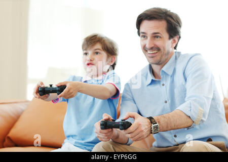 father and son play video game Stock Photo