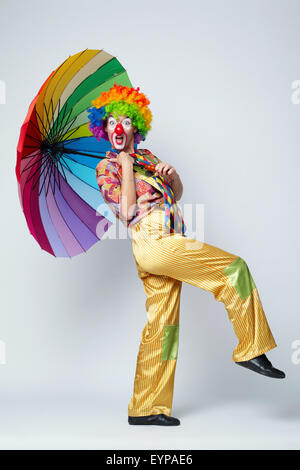 clown with colorful umbrella on white Stock Photo