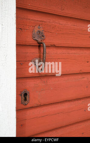 Old rusty door handle and keyhole at a red weathered door Stock Photo