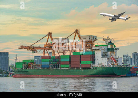 Container Cargo freight ship with working crane loading bridge in shipyard at dusk for Logistic Import Export background Stock Photo