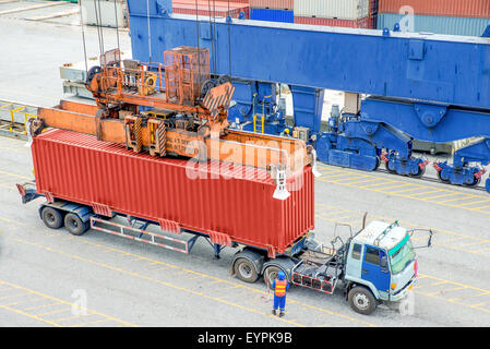 Container truck waiting for loading container box to Cargo ship Stock Photo